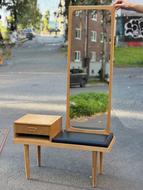 Stilig vintage 1960-talls entresett i eik ✨ Benk med skuff og sete i sort skai, og speil med eikeramme. I god vintagestand. Bitte litt patinert glass på speilet🪞- helt slik gamle speil skal være, i mine øyne! 
Mål: Speil 42 x 117 cm. Benk 90 x 36 H 53,5 cm. Bitte litt bruksspor som normalt mtp alder/bruk. Selges samlet for 3000 kr. Kjøpe nå med Vipps? Send melding. Må hentes, sendes ikke. (Jeg har ikke oppbevaringsplass til solgte møbler i butikken).