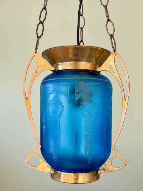 Den blå diamant💙Fantastisk fin antikk  måneskinnslampe i messing og blått glass, jugend / art nouveau fra tidlig 1900-tall. Det etsede blomstermønsteret er jo bare helt nydelig 😍 dette er et smykke, helt magisk blåfarge! Beslaget i messing ser nesten ut som vinger og er i klassisk jugendstil. Glass- og messing-kuppelen kom uten lenkeoppheng, men jeg har funnet et av litt nyere dato som passer helt perfekt til, slik at lampen enkelt kan henges opp og brukes med vanlig lyspære i. Kobles til sukkerbit i taket. Hel og pen med litt patina som så gamle ting skal ha. H kuppel inkl messingbeslag: 32 cm. Ø messing øverst på kuppel 18,5 cm. H inkl lenke og takkopp: ca 115 cm. (Lenken kan jo enkelt forkortes ved å ta av noen ledd). Pris: 3800 kr. Ønsker du å kjøpe denne nå med Vipps? Send melding. Lampen må hentes. Jeg sender ikke knuselige ting i posten.